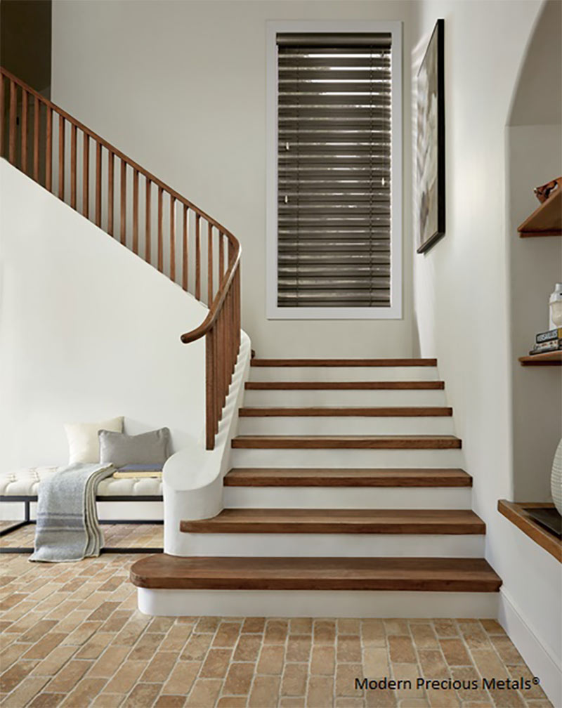Brown wooden stairs with aluminum window blinds and white walls
