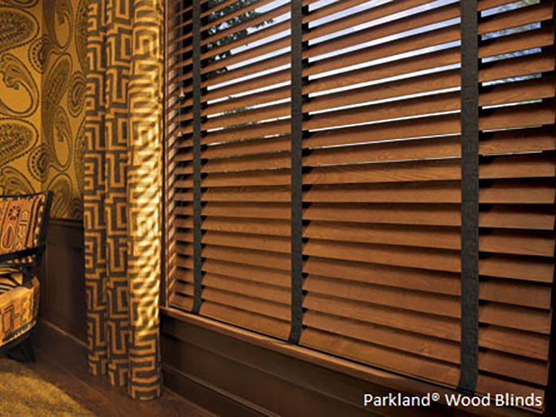 Brown wood window shades with yellowy wall and char on the left