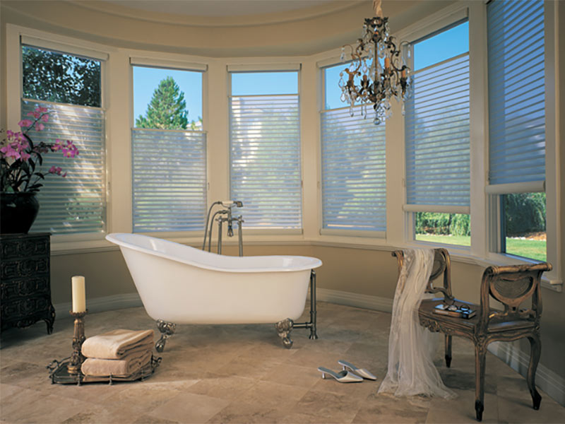 Bathroom with brown tiles, white tub and large windows